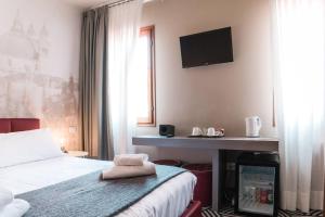 a hotel room with a bed and a television on the wall at Hotel Cannaregio 2357 in Venice