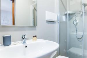 a white bathroom with a sink and a shower at Hotel Cannaregio 2357 in Venice