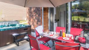 a patio with a table and chairs and a hot tub at Plein Sud avec Jacuzzi Privatif et parking privé in Sarlat-la-Canéda
