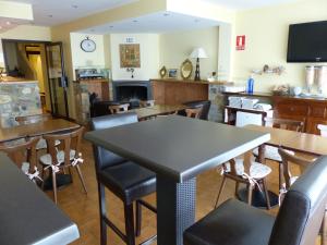 a restaurant with tables and chairs and a fireplace at Hotel Les Truites Adults only in Pas de la Casa
