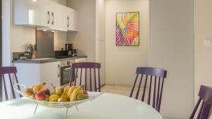 a kitchen with a bowl of fruit on a table at Plein Sud avec Jacuzzi Privatif et parking privé in Sarlat-la-Canéda +9 photos