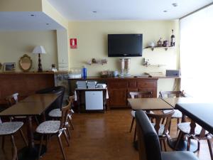 een restaurant met tafels en stoelen en een flatscreen-tv bij Hotel Les Truites Adults only in Pas de la Casa