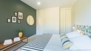 a bedroom with a large bed with blue walls at Plein Sud avec Jacuzzi Privatif et parking privé in Sarlat-la-Canéda