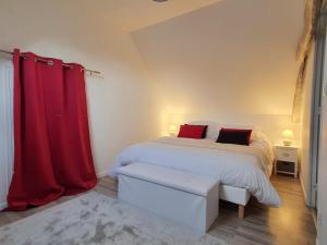 1 dormitorio con cama y cortina roja en Gîte de Palesne - Pierrefonds, en Pierrefonds