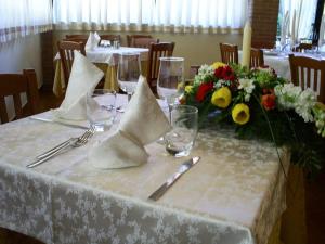 una mesa con un mantel blanco con flores y copas de vino en Bed & Breakfast Nettuno, en Comun Nuovo