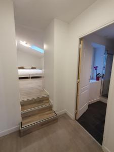 einen Flur mit einer Treppe, die zu einem Zimmer mit einem Bett führt in der Unterkunft Gîte de Palesne - Pierrefonds in Pierrefonds
