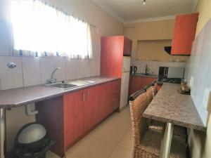 een keuken met rode kasten en een aanrecht bij Aquila Guest House in Pretoria