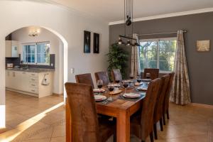 a dining room with a wooden table and chairs at Quinta das Lameiras in Lagoa