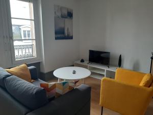 a living room with a couch and a table and a tv at LE 1 " GÎTES TOUT CONFORT à COLMAR CENTRE" in Colmar