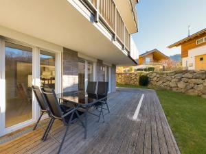 una terrazza in legno con tavolo e sedie. di GardenLodge a Garmisch-Partenkirchen