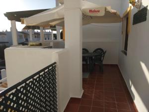 a balcony with a table and an umbrella at Apartamento La Atalaya C-162 in Conil de la Frontera