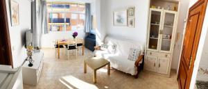 Aurinko 4 Luminoso apartamento en Fuengirola في فوينخيرولا: غرفة معيشة مع أريكة بيضاء وطاولة