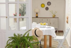 a dining room with a white table with a white table cloth at LEÓN BLANCO CARMONA céntrica, reformada y terraza con vistas in Carmona