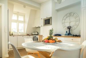una cocina con una mesa con un bol de fruta. en Sky and Sea by Renters Prestige en Sopot