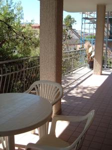 una mesa y 2 sillas en un porche con mesa, mesa y sillas en Walhalla, en Alba Adriatica
