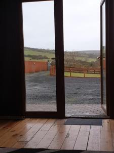 une porte ouverte avec vue sur un champ extérieur dans l'établissement CASTLE-VIEW, à Castlerock