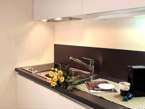 a kitchen counter with a sink with flowers on it at La Loggia in Chiavenna