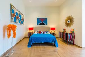 a bedroom with a bed with a blue bedspread at La Gatta Cenerentola Rooms in Naples