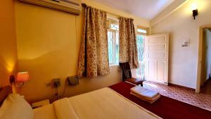 a bedroom with a large bed and a window at Ruby Apartments 4 in Calangute