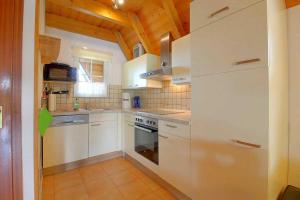 a kitchen with white appliances and a wooden ceiling at Strandvogt 2 ES7 in Dorum Neufeld