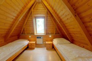 two beds in a wooden room with a window at Strandvogt 2 ES7 in Dorum Neufeld
