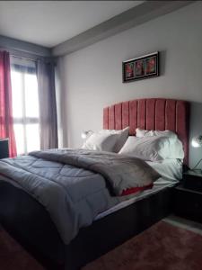 Schlafzimmer mit einem großen Bett mit einem roten Kopfteil in der Unterkunft Porto Said in Port Said