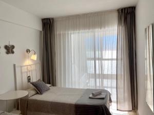 a bedroom with a bed and a large window at Los Gemelos 1 - Aloturin Benidorm in Benidorm