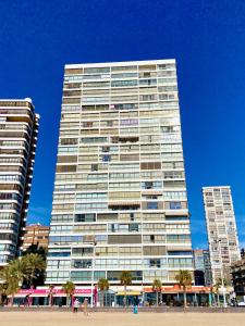 a tall building with palm trees in front of it at Los Gemelos 1 - Aloturin Benidorm in Benidorm