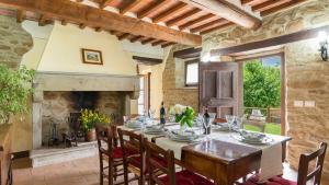 a dining room with a table and a fireplace at La Torretta 10 Emma Villas in Cortona