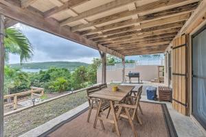 Un patio al aire libre con una mesa y sillas de madera. en Culebra Bungalow with Bay Views and Modern Amenities!, en Culebra