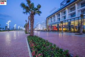 a building with a palm tree in front of it at One Bedroom Apartment - Porto Said in Port Said