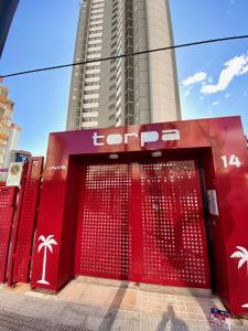 a red door in front of a tall building at Torpa - Aloturin Benidorm in Benidorm