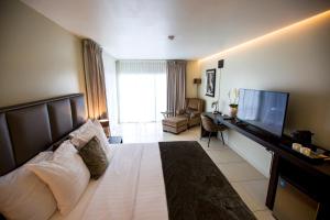 a hotel room with a bed and a television at Tucan Resort & Spa in Paramaribo