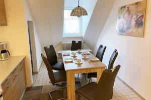 a dining room with a wooden table and chairs at Cozy apartments Eslohe in Eslohe