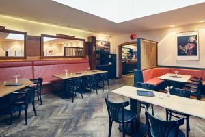 a restaurant dining room with tables and chairs at art Hotel Tucholsky in Bochum