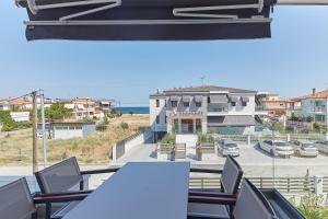 a balcony with chairs and a view of a building at Albatros Luxury Suites in Nea Vrasna