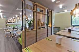 une salle à manger avec des tables et des chaises en bois dans l'établissement Super 8 by Wyndham Oberhausen am Centro, à Oberhausen