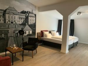 ein Schlafzimmer mit einem Bett, einem Sofa und einem Stuhl in der Unterkunft Altstadthotel Arte in Fulda