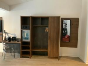 Habitación con escritorio y armario de madera. en Altstadthotel Arte, en Fulda