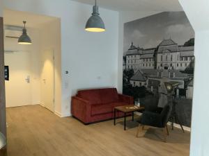 a living room with a red couch and a table at Altstadthotel Arte in Fulda