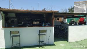 um pequeno bar com dois bancos num edifício em Casas Rurales Villa Vicenta em Alcalá del Júcar