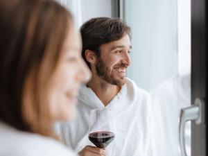 Ein Mann, der ein Glas Wein neben einer Frau hält. in der Unterkunft Novotel Hildesheim in Hildesheim