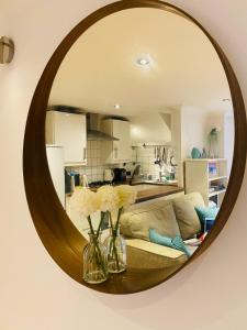 a living room with a couch and a mirror at Stunning, peaceful entire flat in the centre of Wimbledon in London