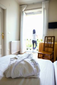 Una toalla sobre una cama en una habitación en Balneario Hotel Dávila, en Caldas de Reis