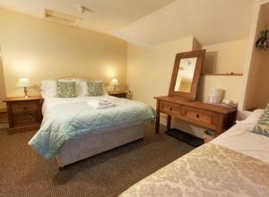 sypialnia z łóżkiem, komodą i lustrem w obiekcie Strands Hotel/Screes Inn & Micro Brewery w mieście Nether Wasdale