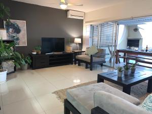 a living room with a couch and a tv at Escape to a Seaside Sanctuary - vayKZN Umdloti in Umdloti