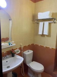 y baño con aseo blanco y lavamanos. en فندق المروج كريم AlMorooj Kareem Hotel, en Yeda