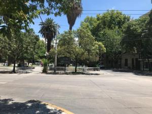 a street with palm trees and a white fence at Alem Colonial - Mendoza in Mendoza