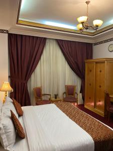 una habitación de hotel con una cama y sillas. en فندق المروج كريم AlMorooj Kareem Hotel, en Yeda