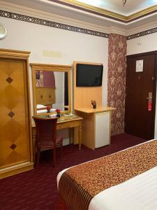 a hotel room with two beds and a desk and a television at فندق المروج كريم AlMorooj Kareem Hotel in Jeddah
